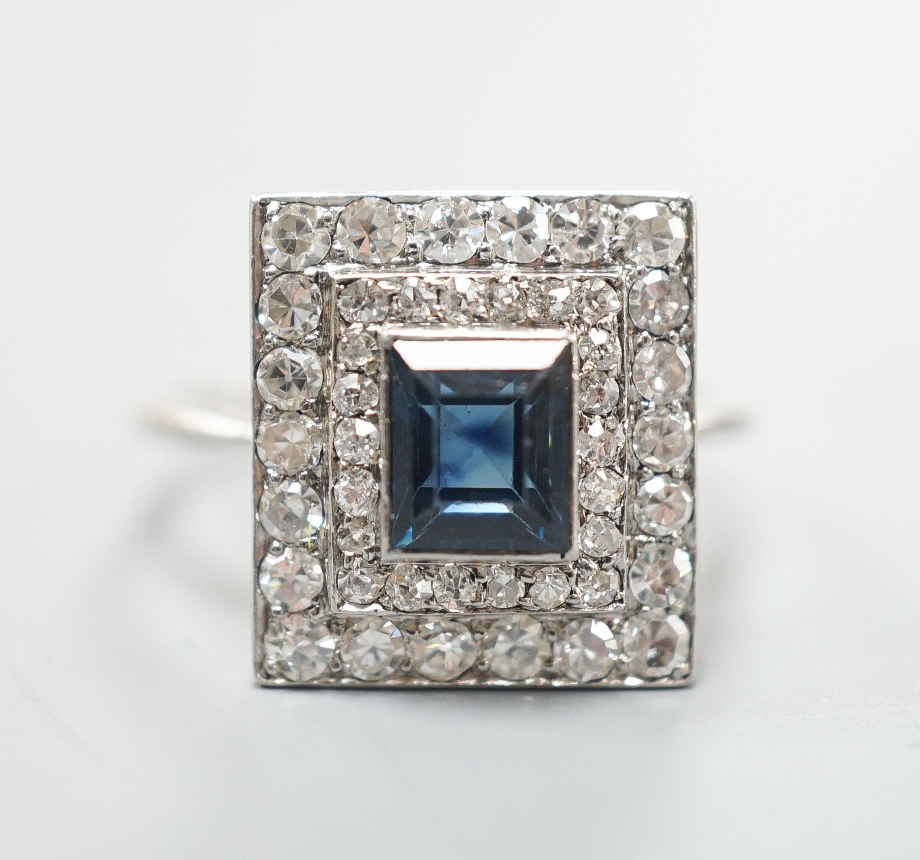 A white metal, sapphire and diamond set square cluster ring, size N, gross weight 4.2 grams.